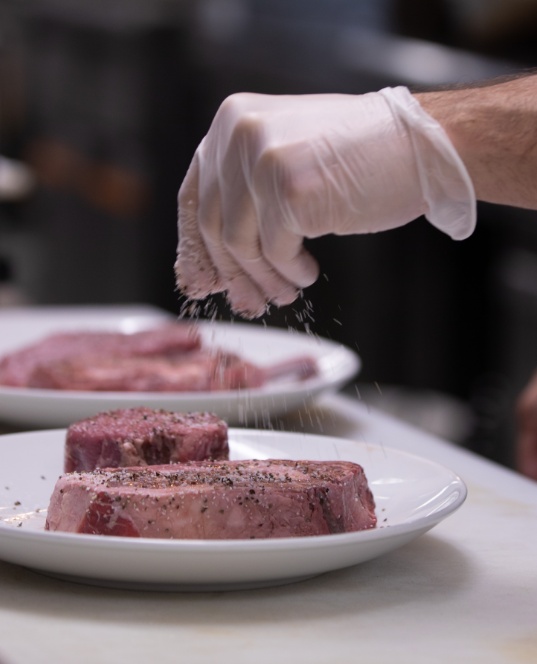 Steak being seasoned